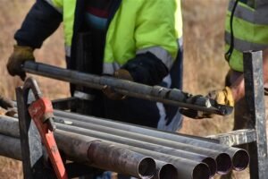 Tau Africa crew handling drill core rods for logging and sampling